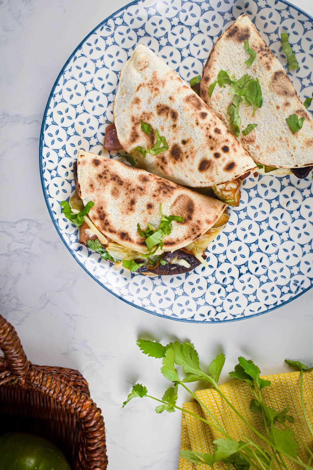 Portobello quesadillas with sliced mushrooms, red onions, zucchini, and cheese in a flour tortilla.