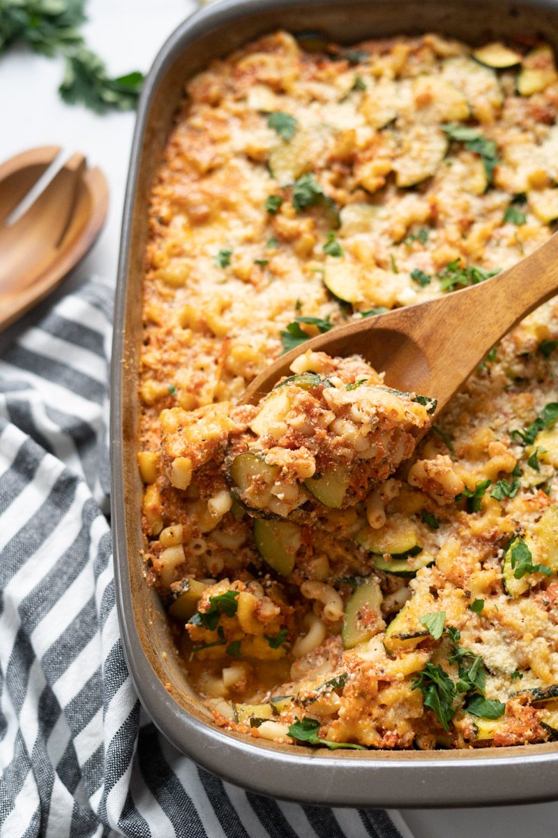 Pasta and zucchini bake with marinara sauce and ricotta cheese baked in a dish with fresh herbs.