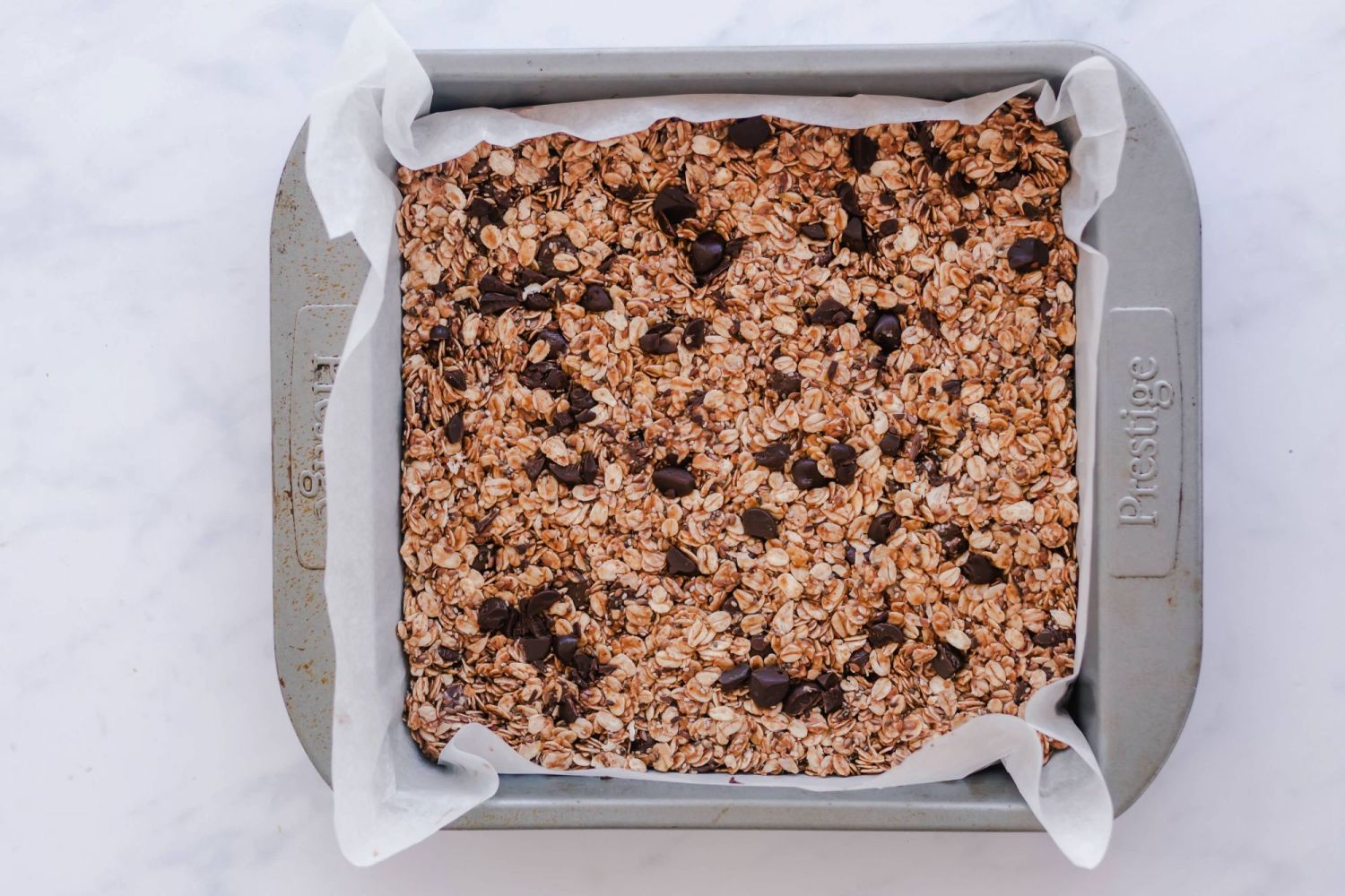 Baking dish with no-bake granola bars with chocolate chips and cinnamon.