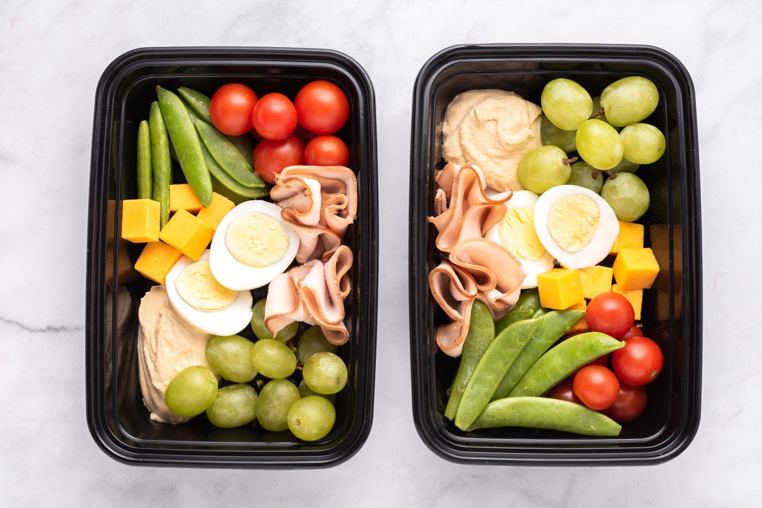 Copycat Starbucks Protein Box Copycat Starbucks Protein Snack Box in two containers with hard boiled eggs, hummus, vegetables, fruit, and deli turkey.