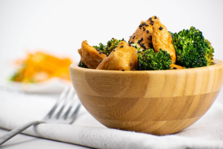 Chicken and Broccoli Stir Fry Chicken broccoli stir fry with stir fry sauce in a wooden bowl with sesame seeds.