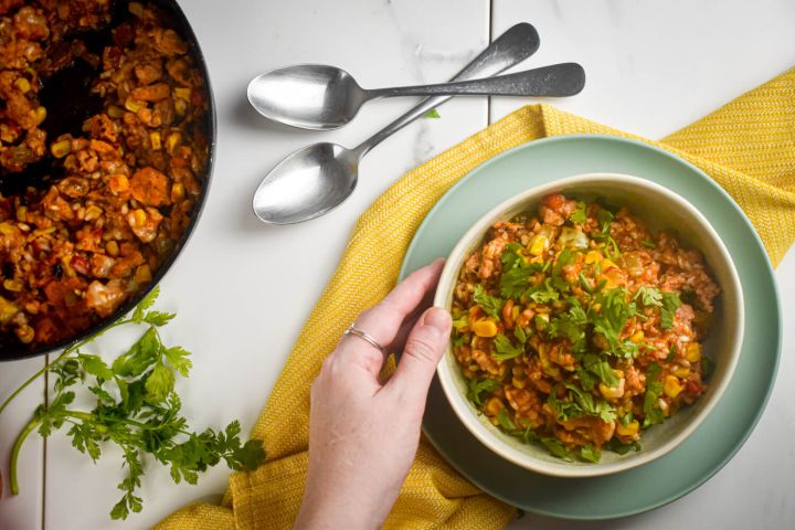 Tex Mex Turkey Taco Skillet Turkey taco skillet with beans, corn, ground turkey, and rice in a bowl with cilantro and green onions.