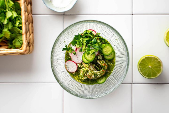 Aguachile Aguachile with raw shrimp in a lime and cilantro sauce in a bowl with sliced cucumbers.