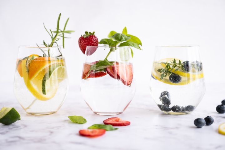 Citrus Detox Water Detoz water in a glass with lemon, lime, and orange slices with rosemary sprigs.