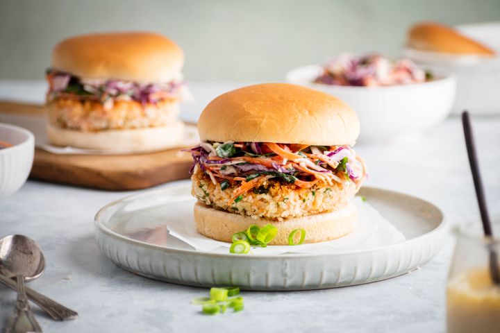 Easy Salmon Burgers Salmon burgers with fresh salmon and spices served on a bun with coleslaw.
