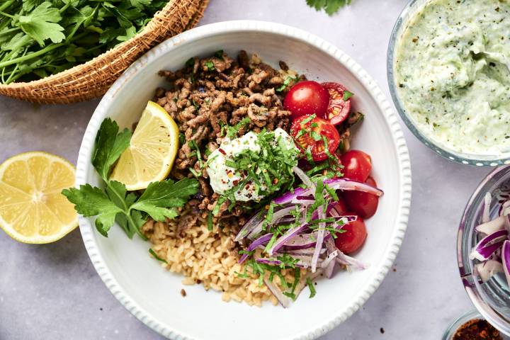 Kofta Ground Beef Bowl with Garlic Tzatziki Kofta ground beef bowls with seasoned ground beef, brown rice, red onion, tomatoes, parsley, and cherry tomatoes.