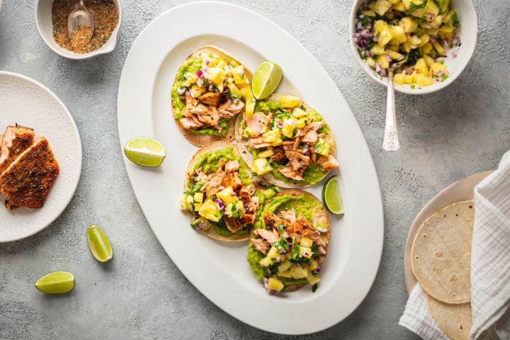 Salmon Tostadas Salmon tostadas with creamy avocado, spice coated salmon, and pineapple salsa on crispy corn tortillas.