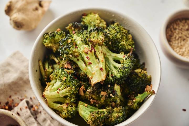 Sesame Broccoli Sesame broccoli with sesame oil, sesame seeds, and soys sauce in a bowl with red pepper flakes and garlic.