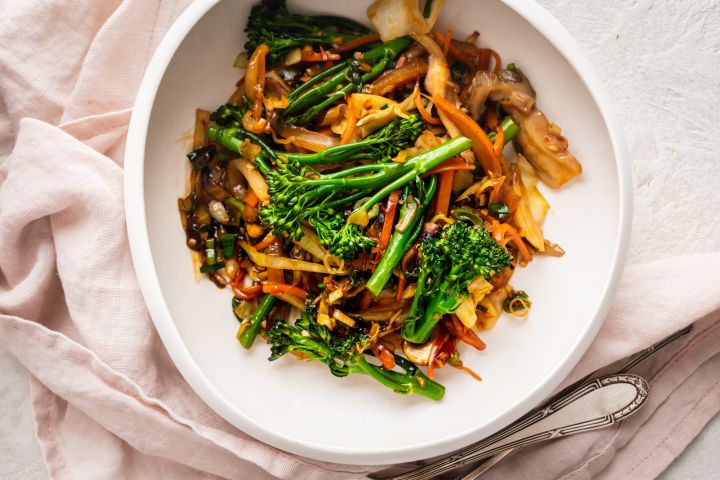 Stir Fried Vegetables (Works for Any Veggies!) Stir fried vegetables with cabbage, mushrooms, broccoli, and carrots in stir fry sauce in a white bowl.