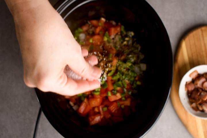 Slow Cooker Charro Beans (Frijoles Charros) Spices being added to a slow cooker for charro beans.