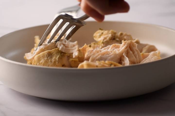 Slow Cooker Jalapeno Chicken Tacos Chicken breast cooked with jalapenos being shredded with two forks.