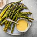 Easy and Delicious Asparagus Recipes Roasted asparagus on a plate with hollandaise sauce.
