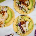 Fish Tacos with Lime Slaw Fish tacos with lime coleslaw on corn tortillas with avocado.
