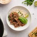 Machaca (Slow Cooker, Instant Pot, or Dehydrated) Beef machaca served with white rice in a bowl with cilantro and avocado on top.