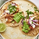 Chicken Tinga Tacos Chicken tinga tacos served on corn tortillas with queso fresco, cilantro, lime, and red onion.