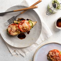 Italian Pesto Chicken Italian pesto chicken baked with sliced tomatoes and melted cheese with a drizzle of balsamic vinegar.