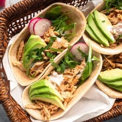 Slow Cooker Barbacoa Chicken Slow cooker barbacoa chicken shredded and served in corn tortillas with avocado and cilantro.