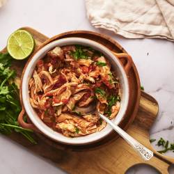 Chicken Tinga (Slow Cooker, Instant Pot, or Stovetop) Chicken tinga in a bowl with onions, cilantro, avocado, and queso fresco.