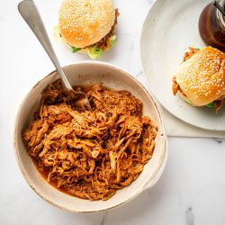 Slow Cooker Spicy Pulled Pork Slow cooker spicy pulled pork with shredded pork tenderloin in spicy barbecue sauce in a bowl.