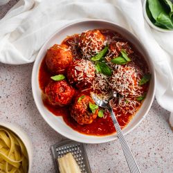 Slow Cooker Turkey Meatballs Slow cooker turkey meatballs in a shallow bowl with marinara sauce, fresh basil, and Parmesan cheese.