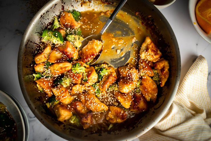 50 Amazing Stir Fry Recipes Stir fried orange chicken with broccoli in a heavy skillet with sesame seeds on top.