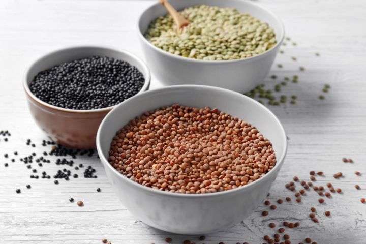 The Beginner's Guide to Lentils Three types of lentils including brown, black, and green in bowls.