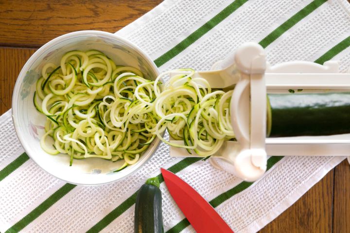Everything You Ever Wanted to Know About Zucchini Noodles Plate of zucchini noodles being made with a spiralizer.