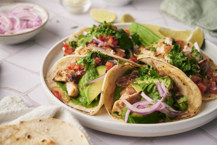 60 Delicious and Easy Taco Recipes Chicken street tacos with avocado, pickled onions, tomatoes, and grilled chicken.
