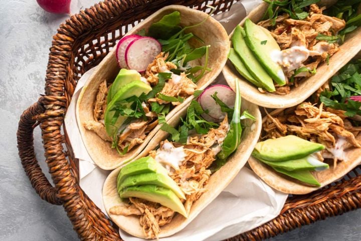 Healthy Slow Cooker Chicken Recipes Healthy slow cooker chicken barbacoa tacos with avocado, cilantro, and radishes in corn tortillas.