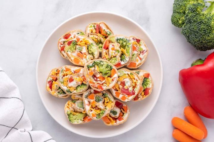 The Best Healthy Party Snacks and Appetizers Healthy cream cheese pinwheels with vegetables served on a white plate/
