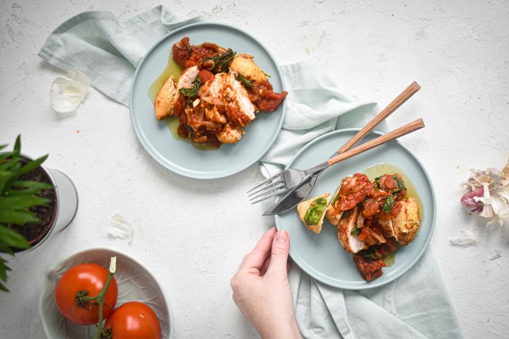 Twenty Five Whole30® Slow Cooker Recipes Whole30 slow cooker chicken breast with tomatoes, spinach, and balsamic vinegar on two plates.