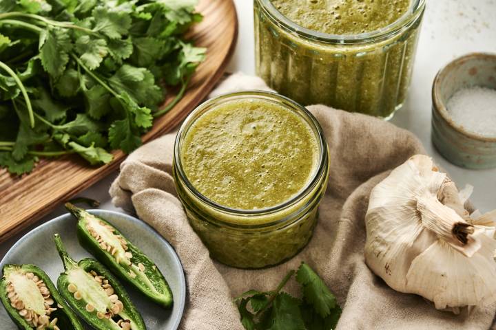 Authentic Green Enchilada Sauce Green enchilada sauce with tomatillos and jalapenos stored in a glass jar.