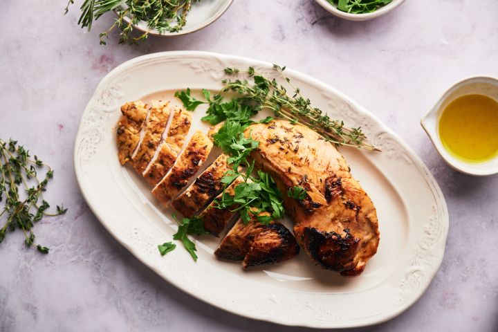 Baked Turkey Tenderloin Baked turkey tenderloin sliced on a plate with fresh herbs.