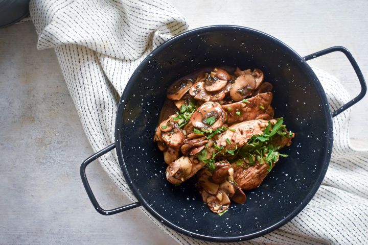 Balsamic Chicken with Mushrooms Balsamic chicken and mushrooms with fresh thyme and parsley in a bowl with a white napkin.
