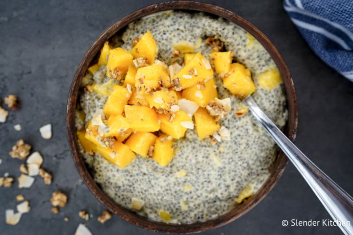 Ultimate Chia Seed Pudding Chia seed pudding with mango on top in a wooden bowl.