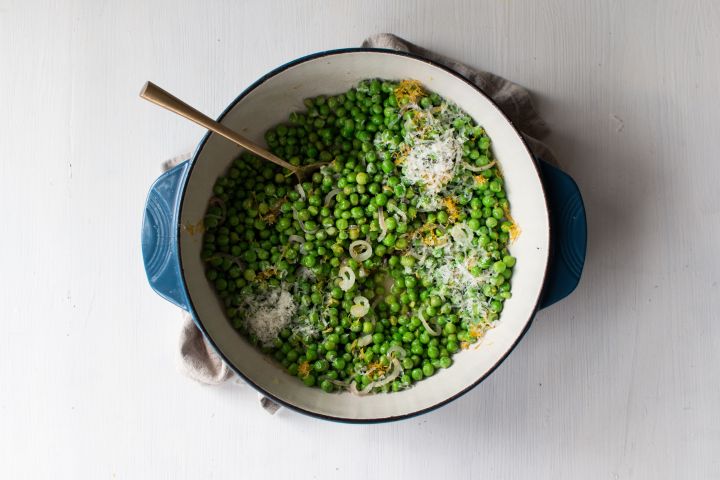 Best Sauteed Peas Sauteed peas with garlic, shallots, lemon, and shredded Parmesan cheese in a ceramic dish.
