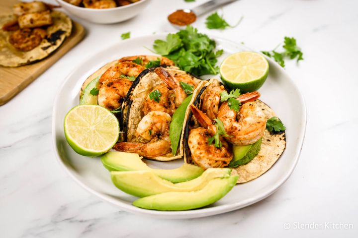 Cajun Shrimp Tacos Cajun shrimp tacos in corn tortillas with sliced avocado, cilantro, and fresh lime juice.
