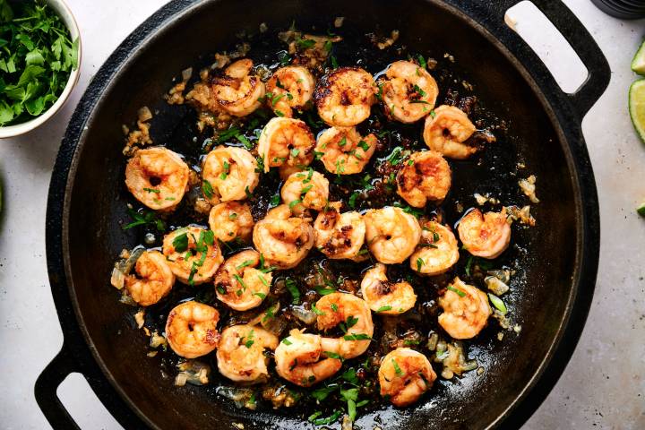 Camarones Al Mojo de Ajo (Mexican Garlic Shrimp) Camarones al mojo de ajo in a skillet with juicy shrimp, garlic, onion, butter, lime juice, and fresh parsley.