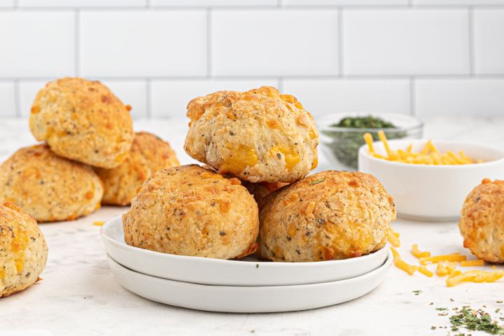Cheddar Biscuits (with Two Ingredient Dough) Cheddar biscuits baked until golden brown piled on a plate.