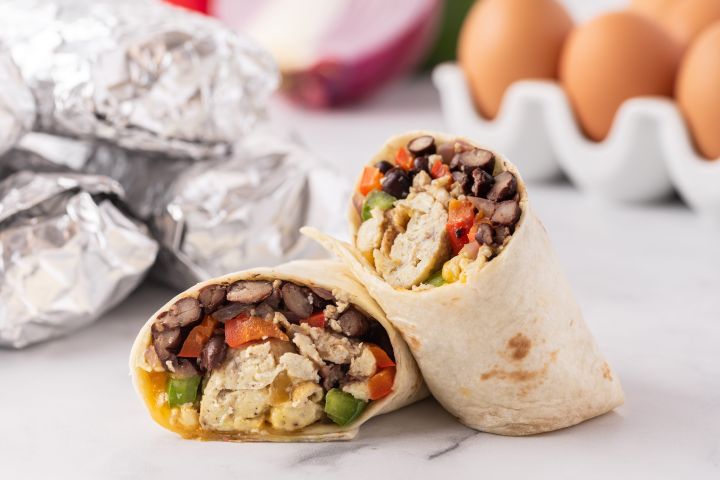 Healthy Freezer Breakfast Burritos Freeezer breakfast burritos with eggs, peppers, black beans, and cheese wrapped in a tortilla.
