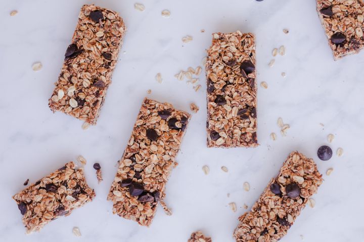 No Bake Granola Bars No bake granola bars with rolled oats, almond butter, chocolate chips, chia seeds, and flax seeds on a marble board.