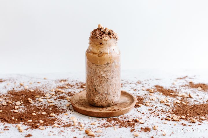 Peanut Butter Chocolate Overnight Oats Chocolate peanut butter overnight oats in a glass jar with peanut butter and cocoa powder.
