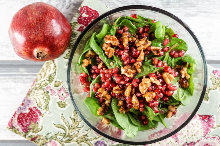 Pomegranate Vinaigrette Pomegranate vinaigrette served over a salad with greens, walnuts, and pomegranate arils.