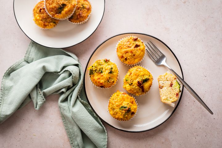 Quinoa Egg Muffins Quinoa egg muffins with cooked quinoa, eggs, broccoli, sundried tomatoes, and shredded cheese served on a plate.