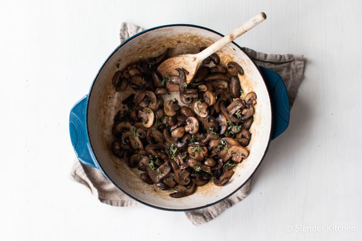 Easy Sautéed Mushrooms with Garlic Butter Sauteed mushrooms with garlic, butter, and thyme in a blue ceramic skillet.