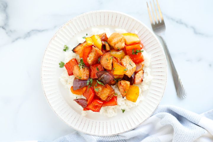 Sheet Pan Honey Sriracha Chicken and Vegetables Sheet pan honey Sriracha chicken and vegetables on a white plate with rice.