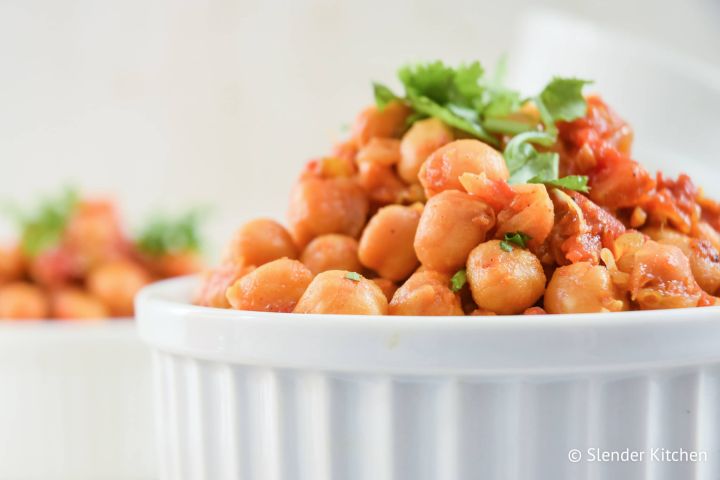Slow Cooker Chana Masala Slow Cooker Chana Masala in a bowl with chickpeas in a curry tomato sauce.