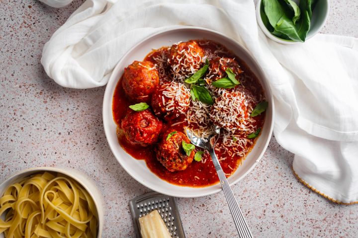 Slow Cooker Turkey Meatballs Slow cooker turkey meatballs in a shallow bowl with marinara sauce, fresh basil, and Parmesan cheese.