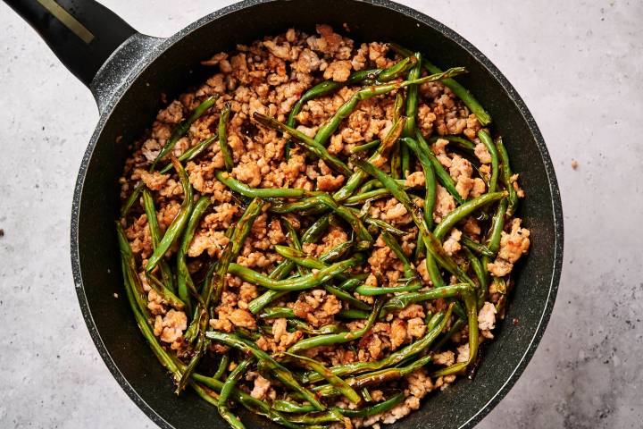 Spicy Ground Turkey and Green Bean Stir-fry Ground turkey and green bean stir fry in a skillet with spicy sauce and chopsticks.