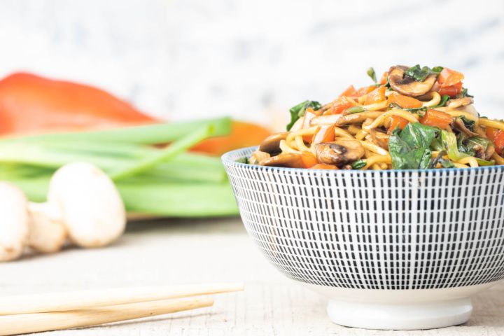 Spinach and Mushroom Lo Mein Spinach and Mushroom lo mein in a bowl with chopsticks picking up noodles.